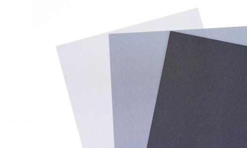 three papers each a different shade of gray