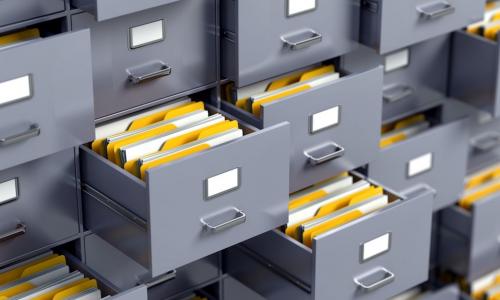 a wall of file cabinets with many open drawers full of folders