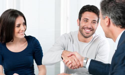 happy member couple shake hands with service representative