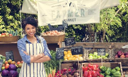 woman selling vegetables at a farmers market