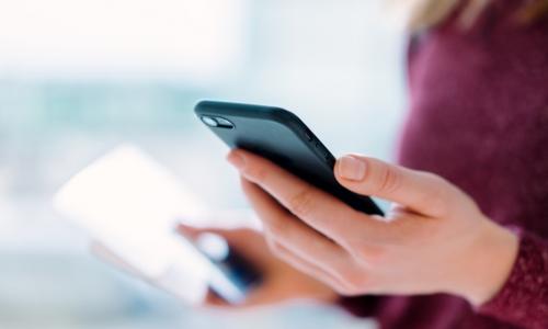 Young woman depositing a check by remote capture with her smartphone