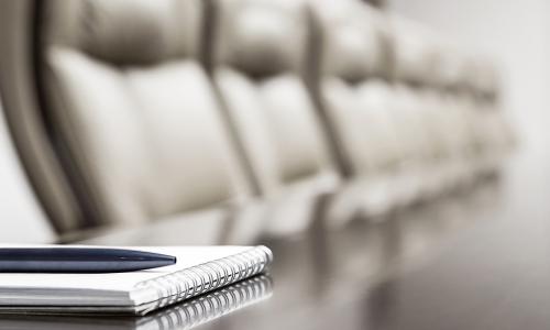 board chairs at a table with a notebook nearby