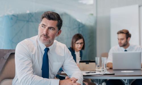 leader in front of other executives working at a table