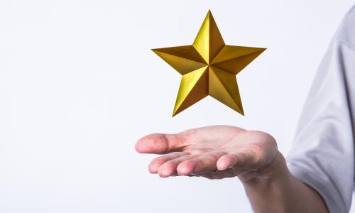 golden star hovering over a man's palm