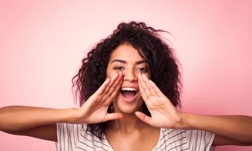 young woman cupping her mouth to be better heard