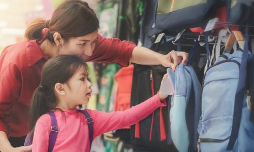 asian mom and daughter shopping for school backpacks