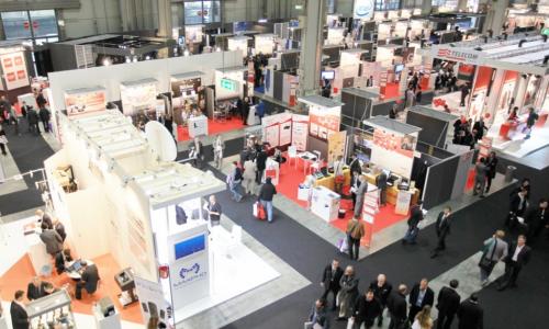 crowds of people visiting booths at a tradeshow