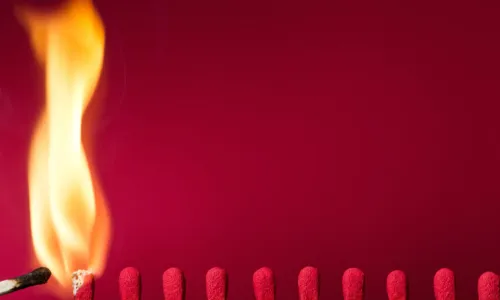 igniting a row of matches on red background