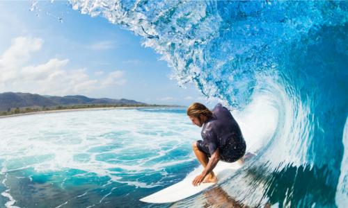 surfer on blue ocean wave in the tube getting barreled