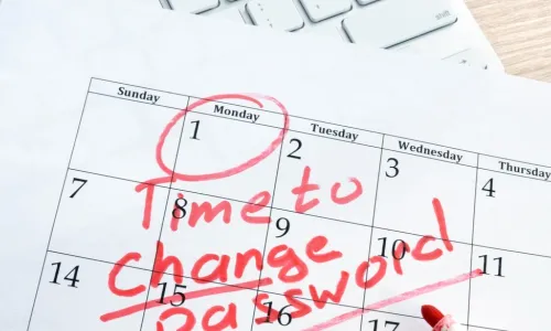 calendar with note to change password laying on a keyboard