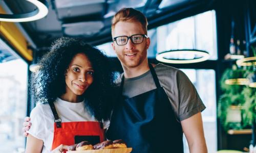 two young male and female bakery owners with baked goods