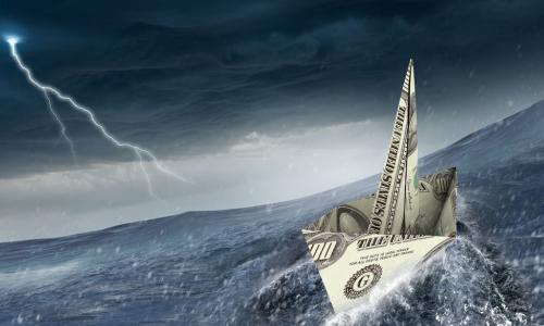 dollar bill origami boat sails into a storm on rough waters