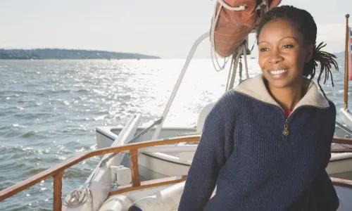 smiling African American woman sailing a sailboat