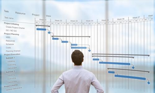 young project manager reviewing a digital Gantt flowchart schedule