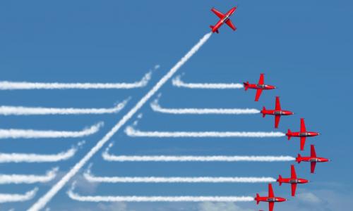 red planes flying in a straight formation with jet streams behind with one plane cutting through on a diagonal