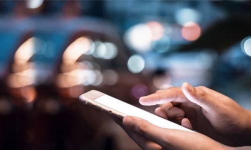 hands interacting with a mobile phone at night