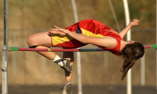 high jumper clearing the raised bar