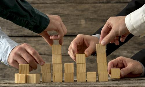 executives stacking wooden blocks