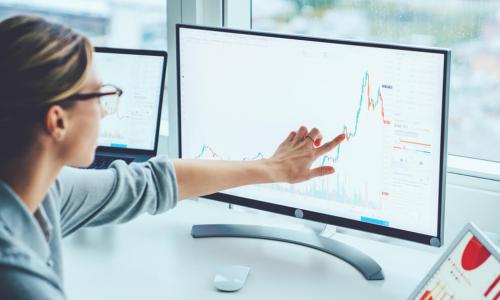 businesswoman using computer and tablet to monitor risks