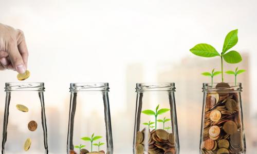 Hand putting Gold coins and seed in clear bottle