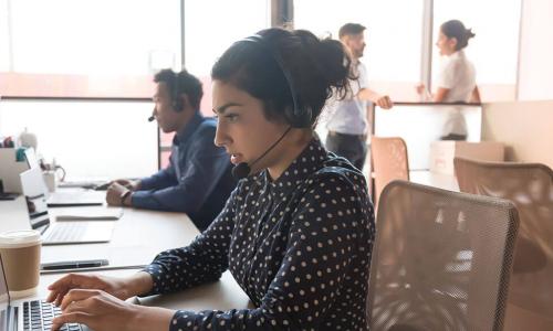 young woman wearing headset working in call center