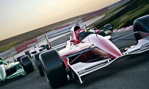 red formula 1 race car speeding along a track