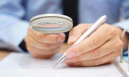 businessman analyzing through magnifying glass