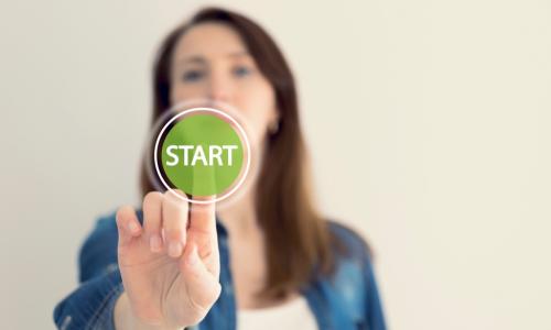 woman presses green start button