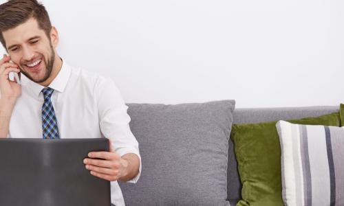 smiling young employee telecommuting with laptop