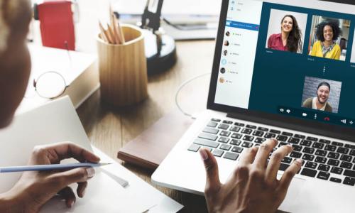 female African American business manager video chats with employee team on laptop