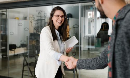 job candidate shakes hands with HR recruiter in pleasant brick office