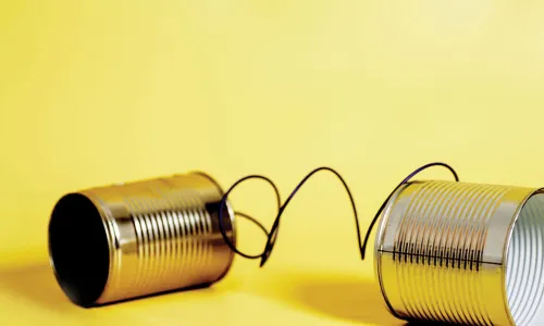 tin-can telephone connected by wire on yellow background