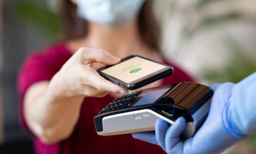 gloved cashier offering credit card reader