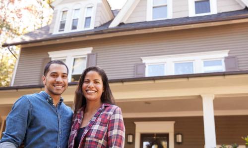 couple standing in front of home