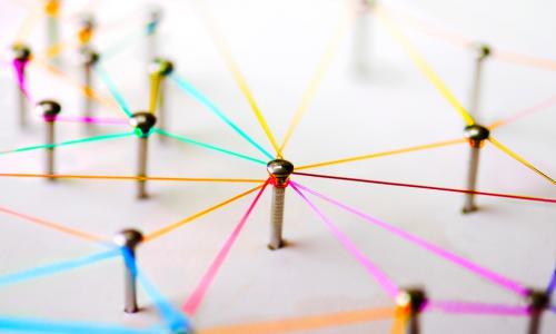 nails in a board connected by colorful string