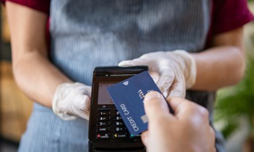 waitress with contactless card reader accepting payment from customer