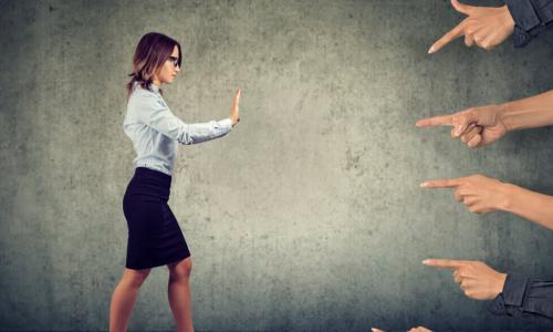 confident woman pushing back at pointing fingers