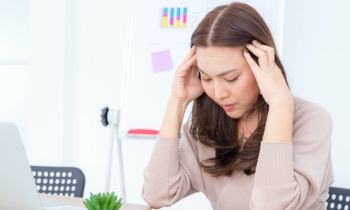sian businesswoman having a headache