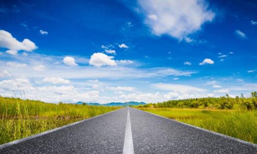 long straight road leading to blue sky