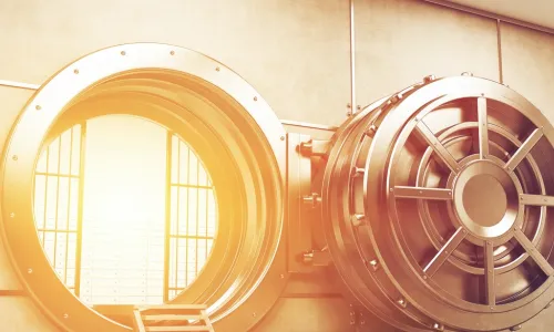 gold light spills out of an open bank vault