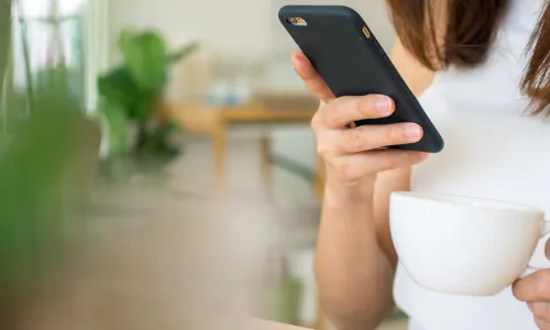 woman drinking coffee with smartphone