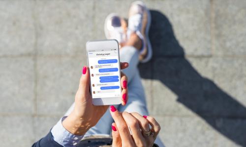 overhead view of a woman using a chat or instant messaging app on her smartphone