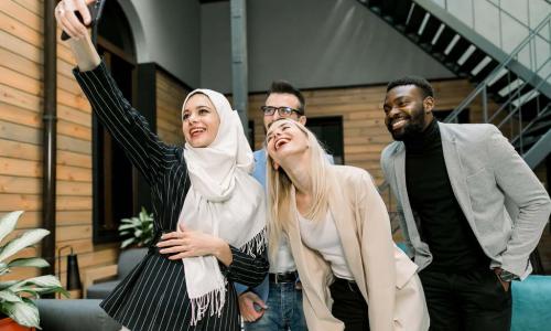 a diverse work team takes a selfie