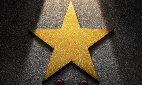 shoes on pavement near star in spotlight