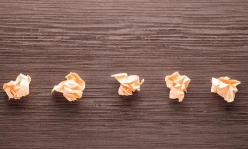 five crumpled pieces of paper on table