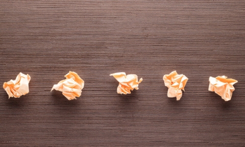 five crumpled pieces of paper on table