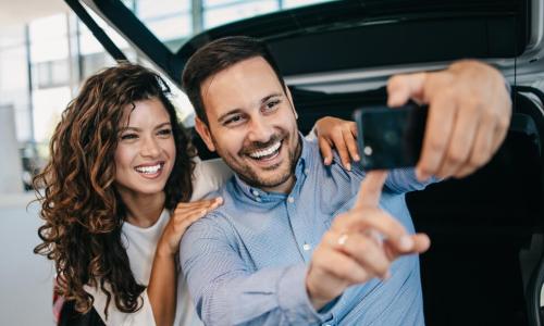 couple takes selfie when buying a card at a dealership