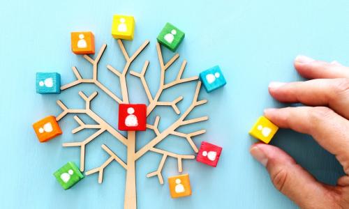 wooden tree with people icons over blue table