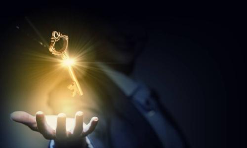 businesswoman with golden key in hand in the dark