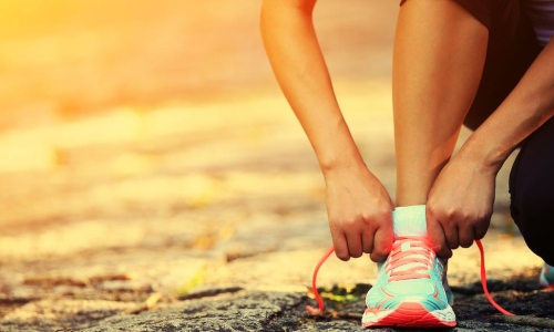 tying athletic shoe